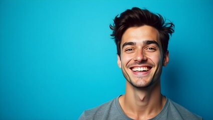 Obraz premium cheerful young man smiling with confidence against vibrant blue background, expressing happiness, positivity and a joyful lifestyle perfect for business and social media use 