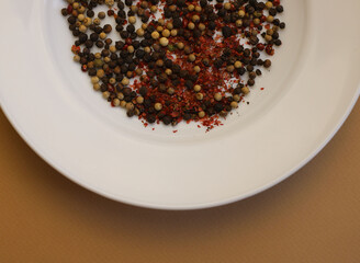 peppercorns black, white and red in a white plate