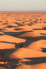 Man sitting on a quad bike in the dunes of the Sahara Desert in Tunisia