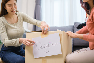group of friend  sorting and packing clothes into a donation box.community support, and charitable giving