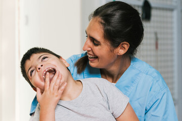 Physiotherapist assisting a child with cerebral palsy smiling and having fun