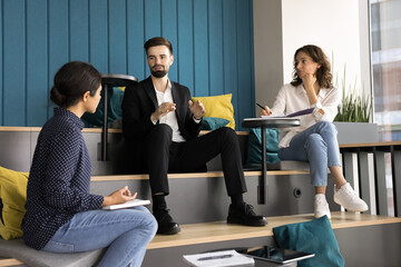 Businessman share corporate goals and meeting agenda met with colleagues in modern auditorium,...