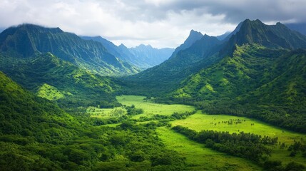 Obraz premium Amidst mountains nature idea. A stunning view of lush green mountains and valleys under a cloudy sky.