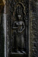 Intricate stone carving of a deity at Angkor Wat.