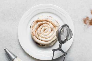 Overhead view of frosting coated cinnamon cookies, top view of cinnamon cookies with a vanilla cream frosting, process of making bakery style cookies