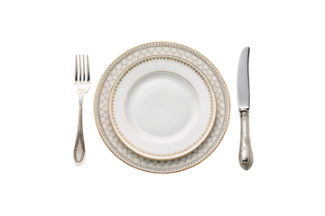 Porcelain dinnerware with interwoven gold patterns on the rim, paired with intricately designed silver-handled cutlery for a regal dining experience, isolated on a transparent background