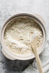 Overhead view of bread dough being mixed in a donabe, top view of homemade bread dough being mixed on granite countertop, process of making artisan bread