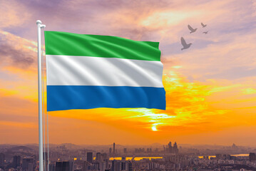 Leone flag for Independence and Commemoration Day. Waving flag of Leone against the background of a sunset or sunrise. Leone sky with flying flag beauty. Concept of national holidays.