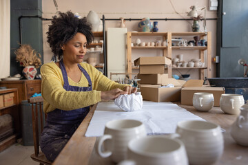 Woman packing up online orders to sell from her craft business