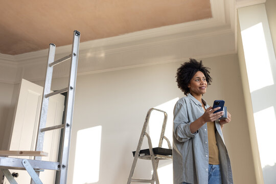 Smiling woman on phone during home improvement