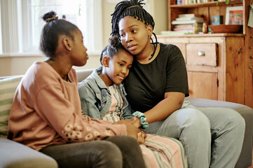 Love, comfort and children with mother on a sofa holding hands, hug and sharing compassion in their...