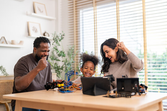 African love family, father mother and daughter learning STEM education, science experiment, robotics toy, technology and innovation interactive learning, creativity and development at home