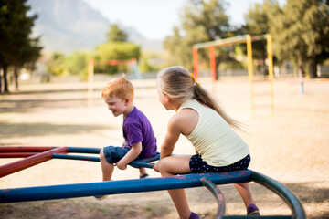 Fototapeta premium Fun, playground and back with kids in park for growth, adventure and merry go round game. Cute, happiness and kindergarten children playing outdoors for exercise, balance and smile on summer holiday