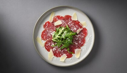Beef carpaccio with arugula and parmesan on a gray background 