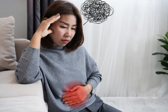 Asian woman suffering from nervous stomach, gut brain axis , feeling discomfort, pain ,connection between stress and digestive discomfort