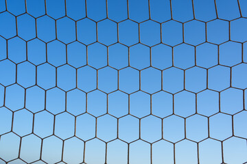 Close-up textured soccer net on soccer goal isolated on free blue sky Backgrund.