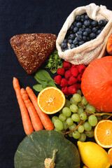 Various healthy fruits, vegetables and cereals on dark background. Top view.