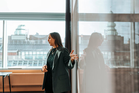 Female entrepreneur discussing in meeting through presentation at office