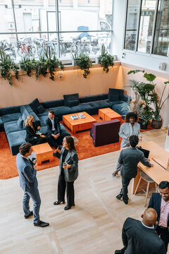 High angle view of male and female business delegates discussing with each other at networking event