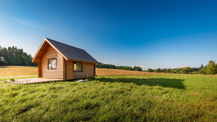 Obraz premium Rural Cabin in Open Fields and Greenery - Stock Image