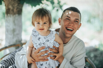 Happy Father Holding Daughter Outdoors