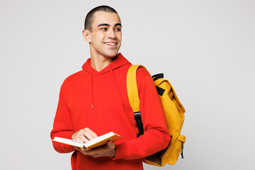 Young smart middle eastern man boy student he wear red casual clothes backpack bag hold read book look aside on area isolated on plain solid white background. High school university college concept.