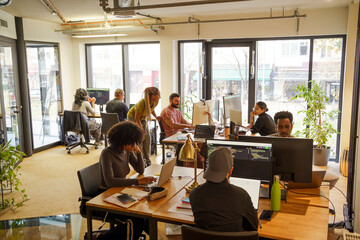Multiracial male and female computer programmers working in tech start hub