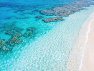 Aerial view of pristine turquoise ocean and sandy beach with coral reef
