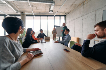 A diverse multiethnic business team engages in a collaborative meeting, discussing strategies and solutions in a modern office setting