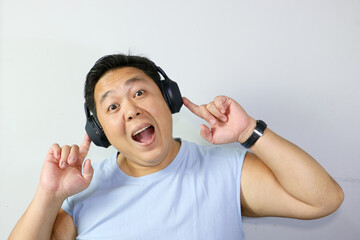 Fototapeta premium Cheerful Man enjoying music with headphones with his mouth open as if singing along