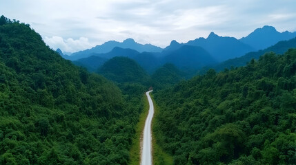 Winding road through lush green mountains, scenic aerial view, travel destination