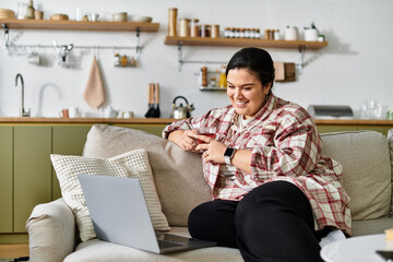 A vibrant and cozy setting features a young plus sized woman sipping tea while using her laptop.