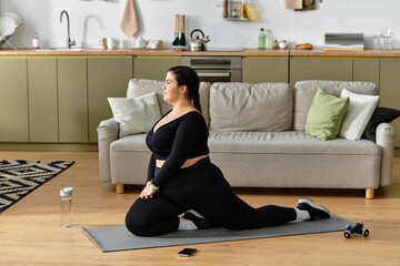 A young plus sized woman stretches elegantly on a yoga mat in her stylish, cozy living room.
