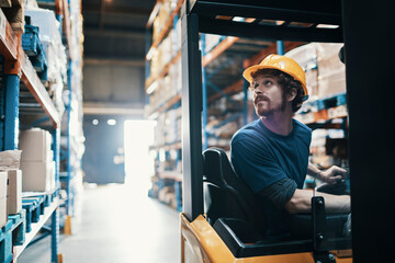Warehouse worker operating forklift in storage facility