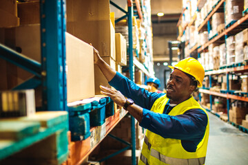 Smiling male warehouse worker organizing boxes in storage facility