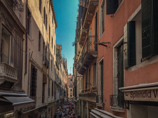 A Narrow Venetian Alleyway.  A narrow alleyway winds between tall, colorful buildings, creating a sense of mystery and intrigue.