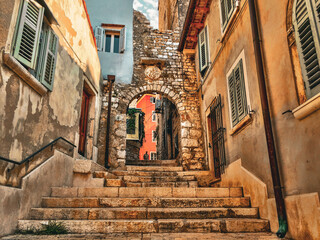 A Charming Rovinj Alleyway. The image shows a narrow passageway lined with old buildings, inviting the viewer to explore the town's hidden corners.