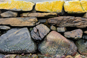 Exploring the ancient textures of Norway's coastal stone walls on a serene summer day