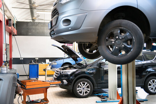 Cars undergoing maintenance and repair in busy auto repair shop