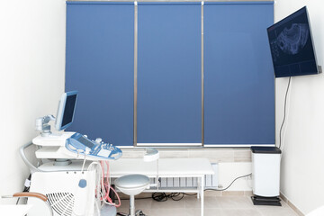 Doctor's office with couch and diagnosis tools. Ultrasound machine for body examination in clinic. Modern hospital with high technology equipment. Health care, diagnostic, disease prevention concept