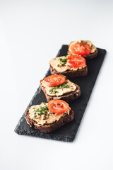 Rustic Pate, man smear on Black Bread with Fresh Herbs and tomatoes