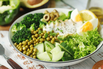 A bowl with a salad made of green vegetables	