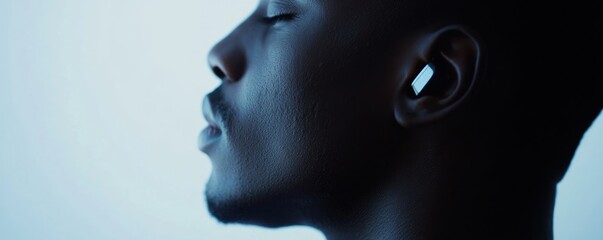 Man wearing earbud, eyes closed, serene face, bright background, audio ad