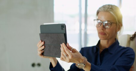 The designer uses a tablet when talking to clients. Close-up of the tablet