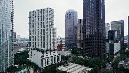 Fototapeta premium A drone flies between glass skyscrapers in the business center of an American city. An ancient church among modern buildings