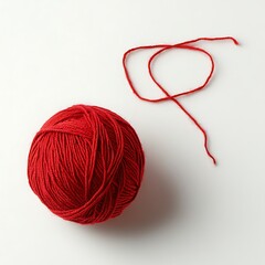 Red yarn ball and loose thread on white background.
