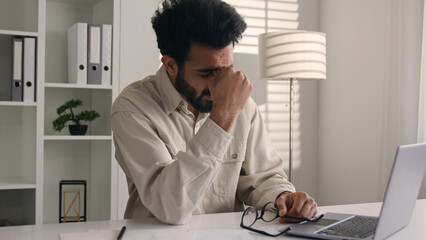 Arabian Indian business man exhausted office employee working laptop computer sick ill tired...