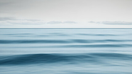 Fototapeta premium Calm ocean waves under a cloudy sky; serene seascape for travel brochure