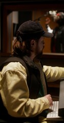 The sound engineer controls the recording process of the song in the studio. Close-up of his face. The rapper sings in the room behind the glass