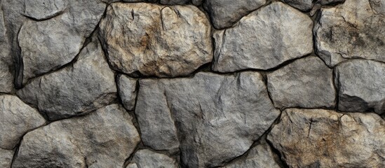 Textured stone wall background with irregular stones in shades of gray and brown suitable for various design applications Copy Space